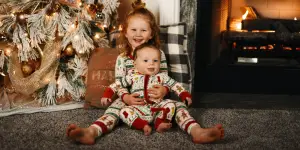 kids; an older girl and a younger boy sitting at the floor near the fireplace