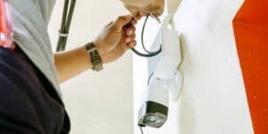 man fixing security camera wires