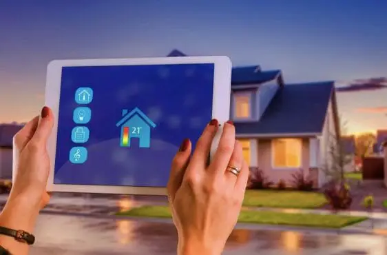 a woman holding a tablet accessing her home security system