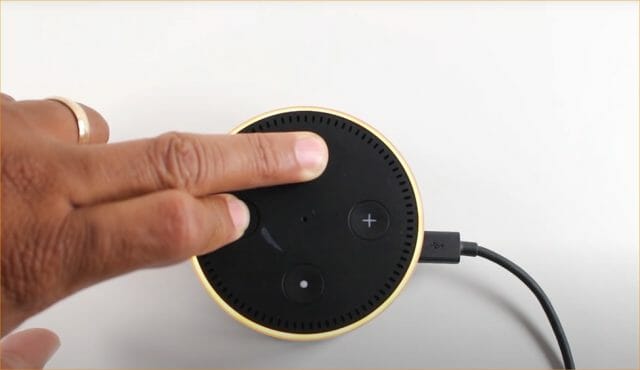man's finger tapping alexa device button