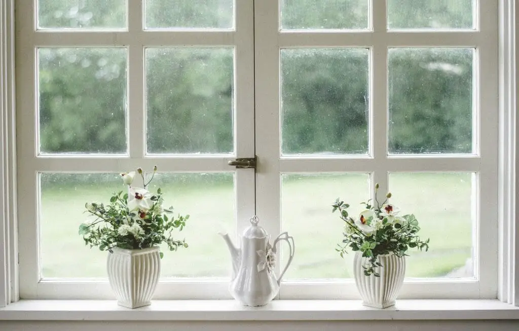 white window with three flower vases