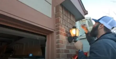 man installing light bulb camera