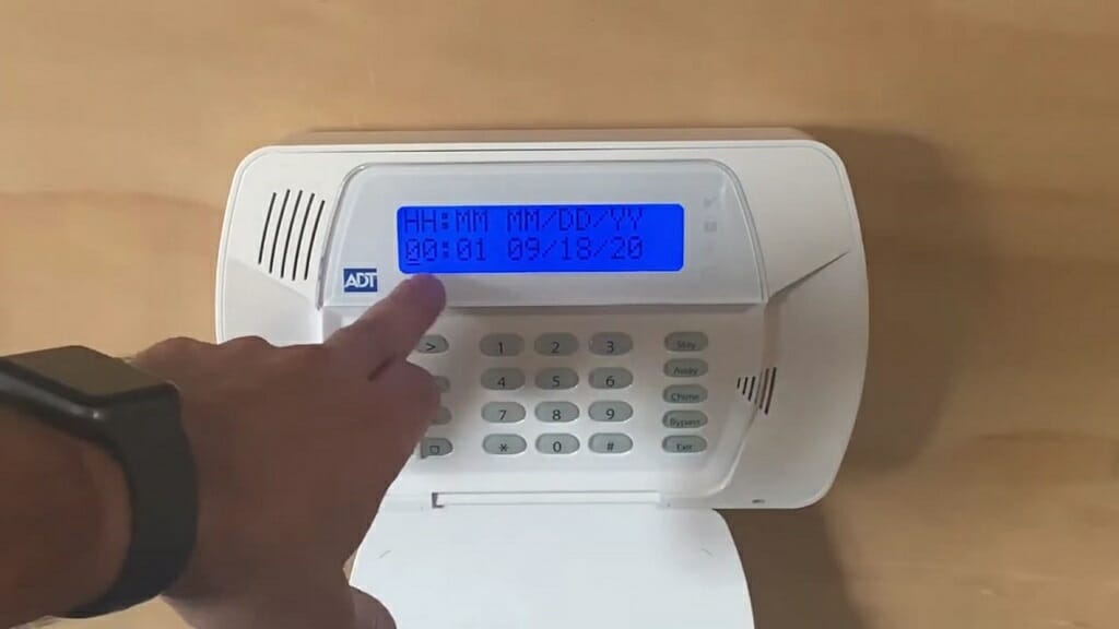 man setting up the hours, minutes, month, day, and year of an ADT device