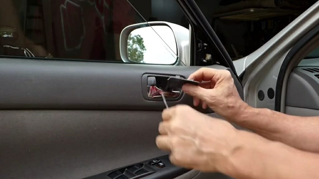 man removing the car door's trim piece