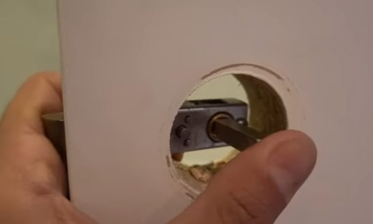 man inserting the lock at the door hole