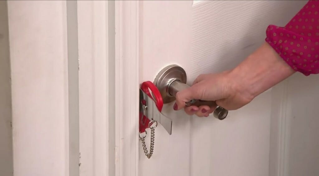 a woman opening the door with the portable door lock