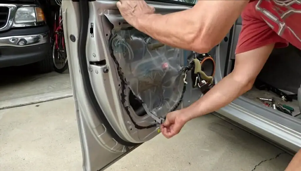 man removing the plastic cover from the car door