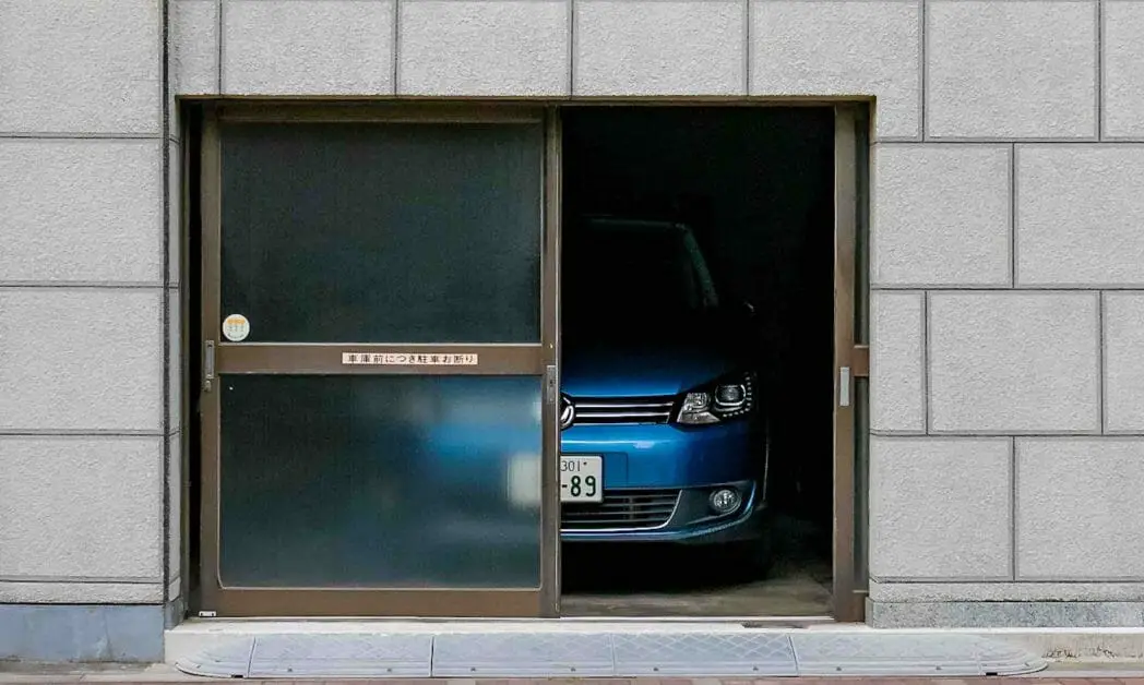 glass sliding garage door with blue car